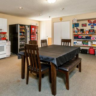 A kitchen and dining area featuring a table with chairs, appliances, and organized shelves.