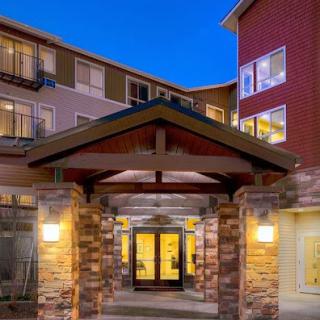 A welcoming entrance to a modern residential building illuminated at dusk.