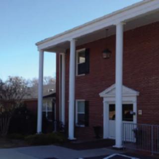 A brick building with large white columns at the entrance.
