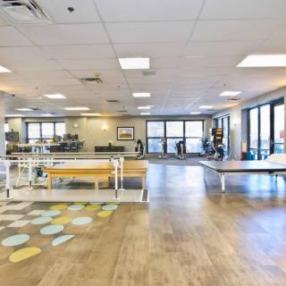 A spacious rehabilitation center with various exercise equipment and therapy areas.