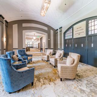 A spacious and elegantly designed lobby with comfortable armchairs and chandeliers.