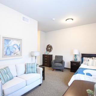 A cozy and well-lit bedroom with modern furniture and decor.