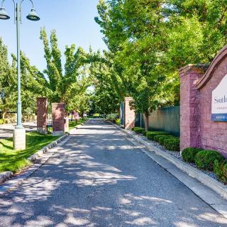 A picturesque driveway lined with trees and bordered by brick walls, leading to an entrance.