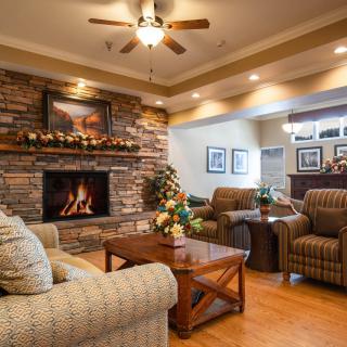 A cozy living room featuring a stone fireplace, comfortable seating, and warm decor.