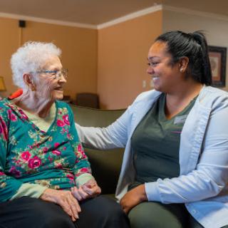 A joyful moment of connection between a caregiver and an elderly resident.