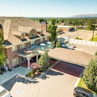 Aerial view of a large residential mansion with a spacious driveway and landscaped backyard.