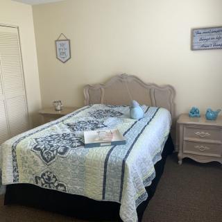A cozy bedroom with a neatly made bed, nightstands, and decorative touches.