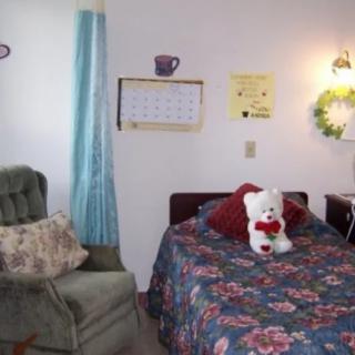 A cozy bedroom with a floral bedspread and decorative items.