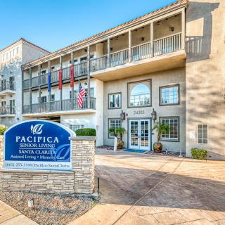 The exterior view of a residential building with visible signage and flags at the entrance.