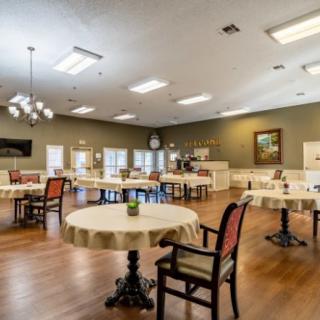 A spacious and well-lit dining room with multiple tables and chairs arranged neatly.