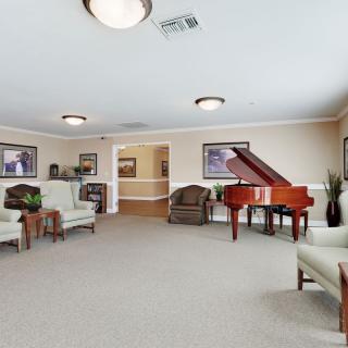 A spacious living room with a grand piano and comfortable seating area.