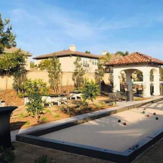 A beautifully landscaped backyard featuring a bocce court and a charming gazebo.