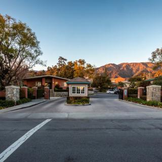Entrance to a gated community with mountains in the background at sunset.