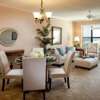 A cozy living and dining space with modern furniture and neutral tones, enhanced by natural light.