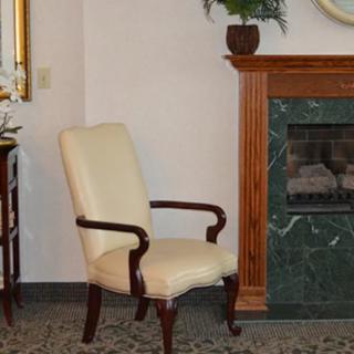 A cozy armchair next to a fireplace in a well-decorated living room.