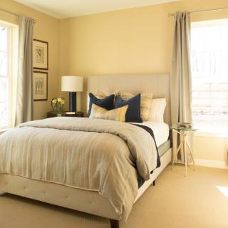 A cozy bedroom with a neatly made bed and ample natural light.