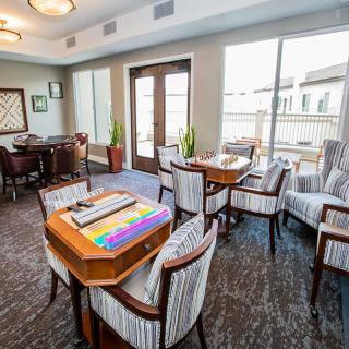 A comfortable and modern lounge area with tables and chairs, featuring board games for entertainment.