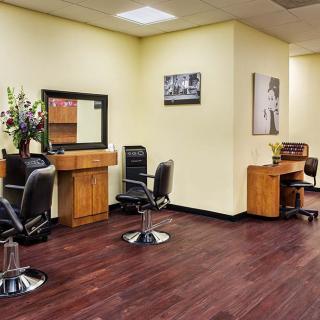 A neatly arranged hair salon interior with styling stations and chairs.