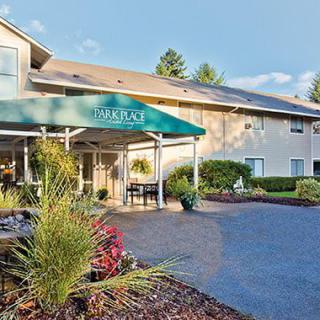 A hotel entrance with a green awning and landscaped surroundings.