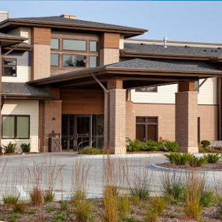 A modern architectural building with a welcoming entrance and landscaped surroundings.