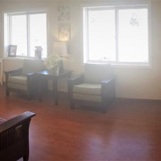 A bright waiting room with chairs and large windows.
