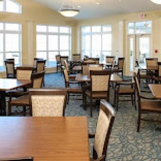 A spacious and well-lit dining area featuring wooden tables and chairs.