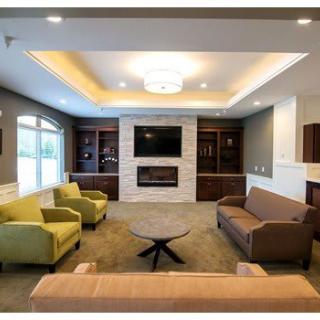 A modern living room with comfortable seating, a fireplace, and a mounted television.