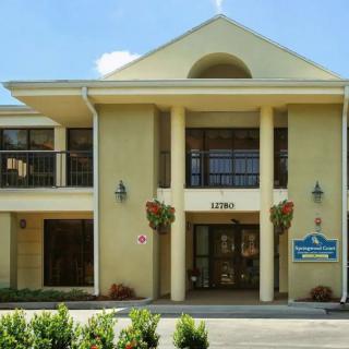 A hotel entrance featuring classical architecture with columns and a welcoming sign.