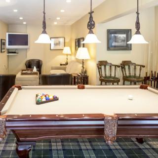 A cozy game room with a classic pool table and warm lighting.