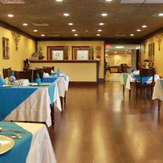 A well-arranged dining area in a restaurant, featuring tables with blue tablecloths and a warm ambiance.