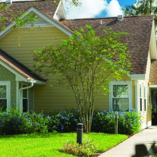 A charming residential house with a well-maintained garden and neatly trimmed lawn.
