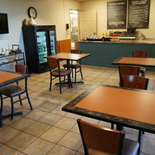 A cozy restaurant interior with tables and a food counter.