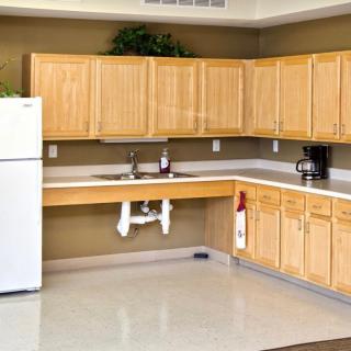 A spacious kitchen with wooden cabinets, a white refrigerator, and a modern countertop.