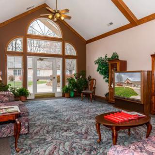 A spacious lobby featuring large windows, elegant furniture, and indoor plants.
