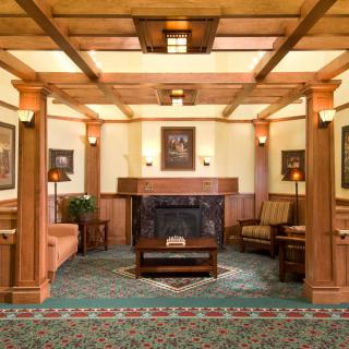 A cozy living room with wood paneling and a central fireplace.