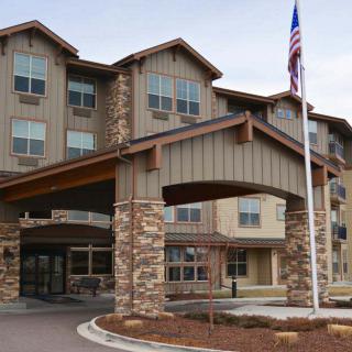 A hotel entrance with a stone facade and an American flag.
