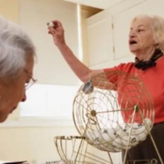 Two seniors enjoying a game of bingo.