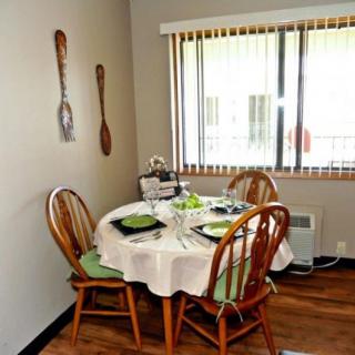 A cozy dining area with a set table for four near a large window.