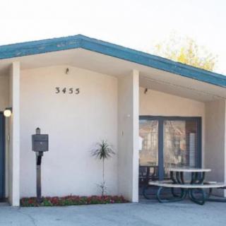 Small, single-story building with a front entrance and outdoor seating.