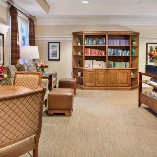 A cozy living room with a bookshelf, comfortable seating, and elegant interior design.