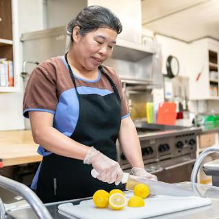 A woman prepares lemons in a kitchen, showcasing the art of food preparation.