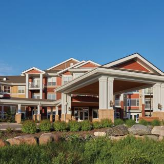 A modern hotel building with a well-landscaped exterior under a clear blue sky.