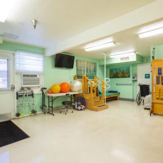 A well-equipped rehabilitation therapy room featuring exercise equipment and a bright, inviting atmosphere.
