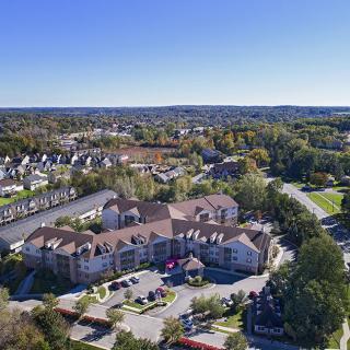 Aerial view of a suburban neighborhood with residential buildings and lush greenery.