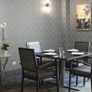 An elegant dining room setup with a modern design, featuring a table set for four.