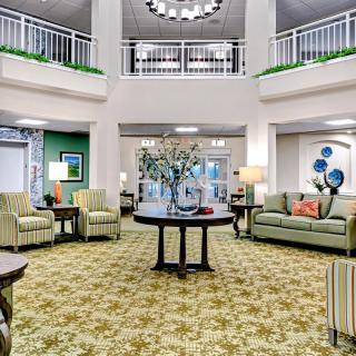 A spacious and elegantly decorated lobby with comfortable seating and a chandelier.