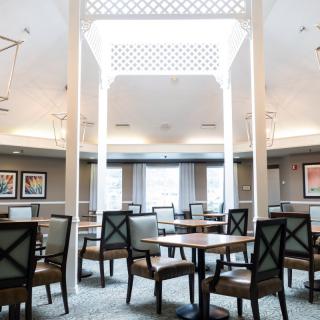 A modern dining area with neatly arranged tables and chairs, featuring elegant interior design elements.