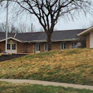 A view of a suburban house with a tree and grassy area.