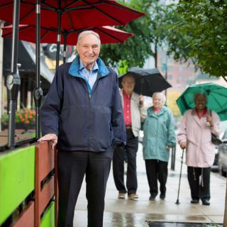 A group of people walking on a rainy street with umbrellas.