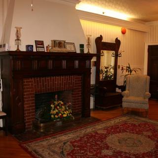 A cozy living room featuring a brick fireplace and vintage furnishings.